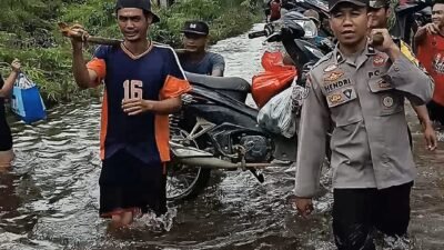 Jalan Lundang Baru Terendam Banjir, Bhabin Polsek Dedai Bantu Warga Pikul Motor